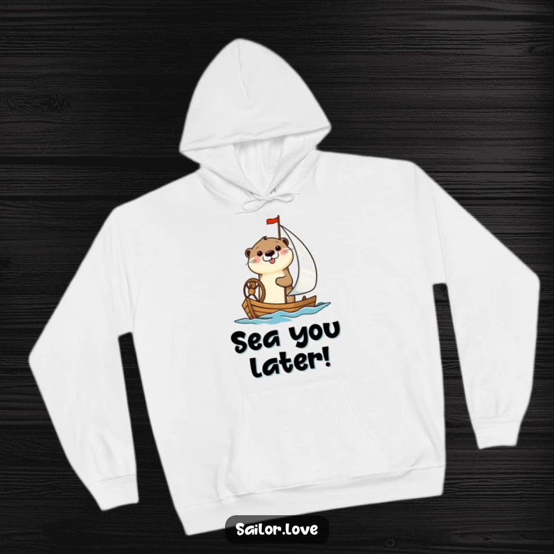 Funny hoodie featuring a cheerful otter happily steering a small sailboat, offering warmth and maritime-themed humor.